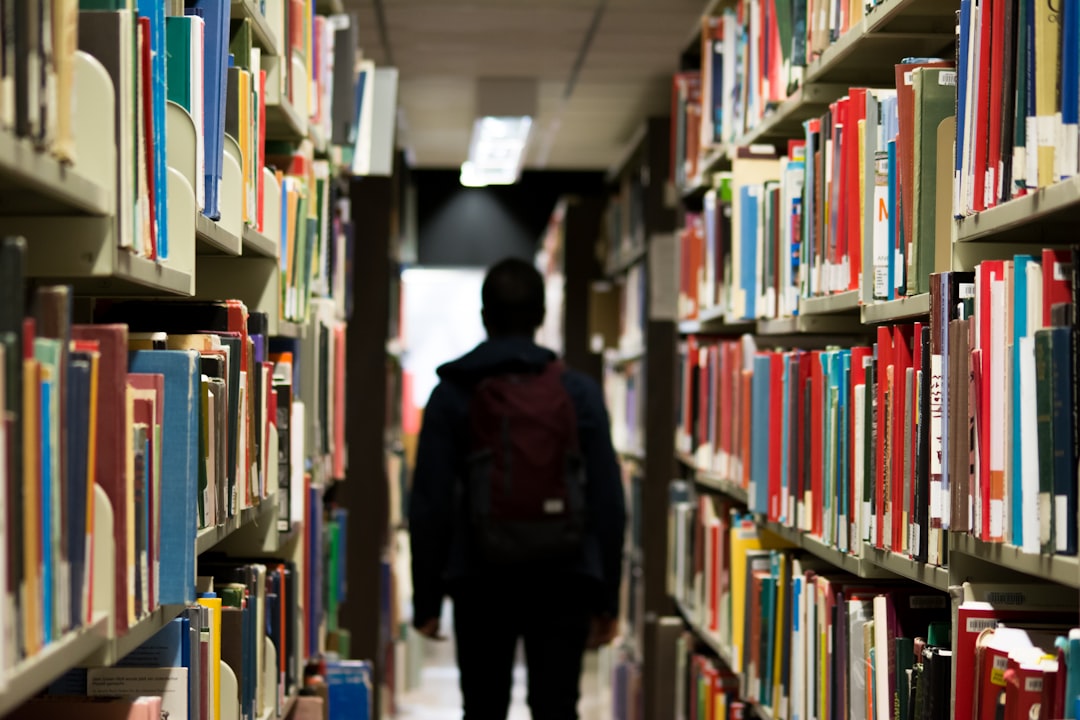 man with backpack beside a books man with backpack beside a books