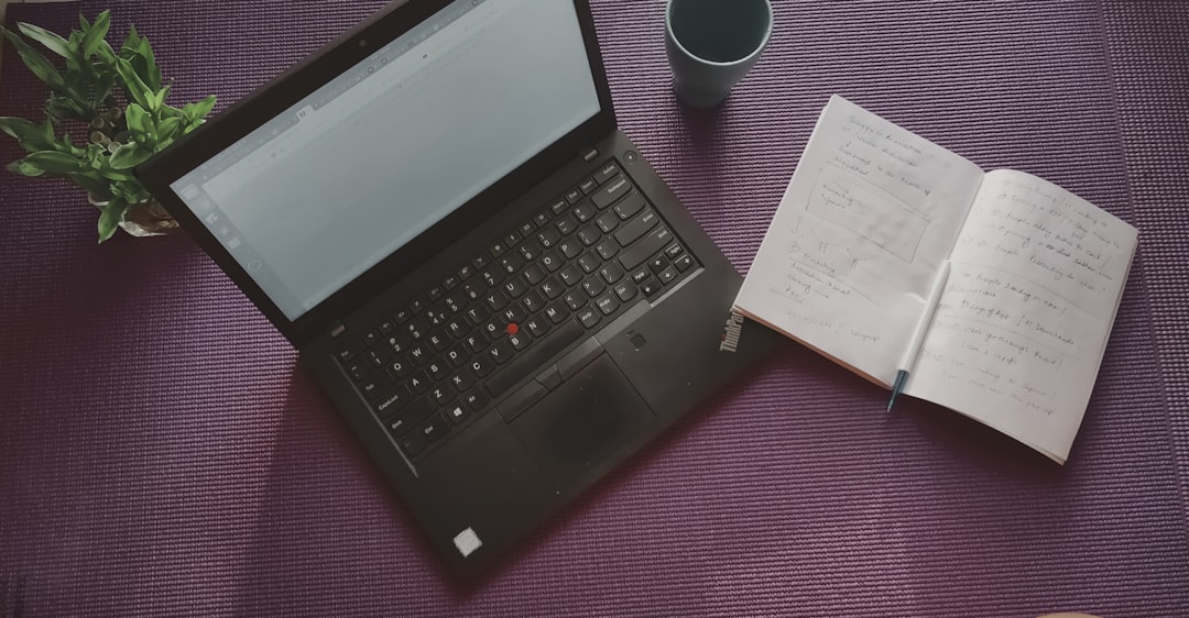 open note book beside black laptop computer open note book beside black laptop computer