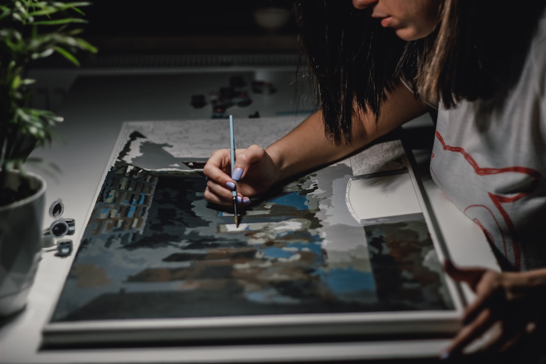 woman painting on white paper woman painting on white paper