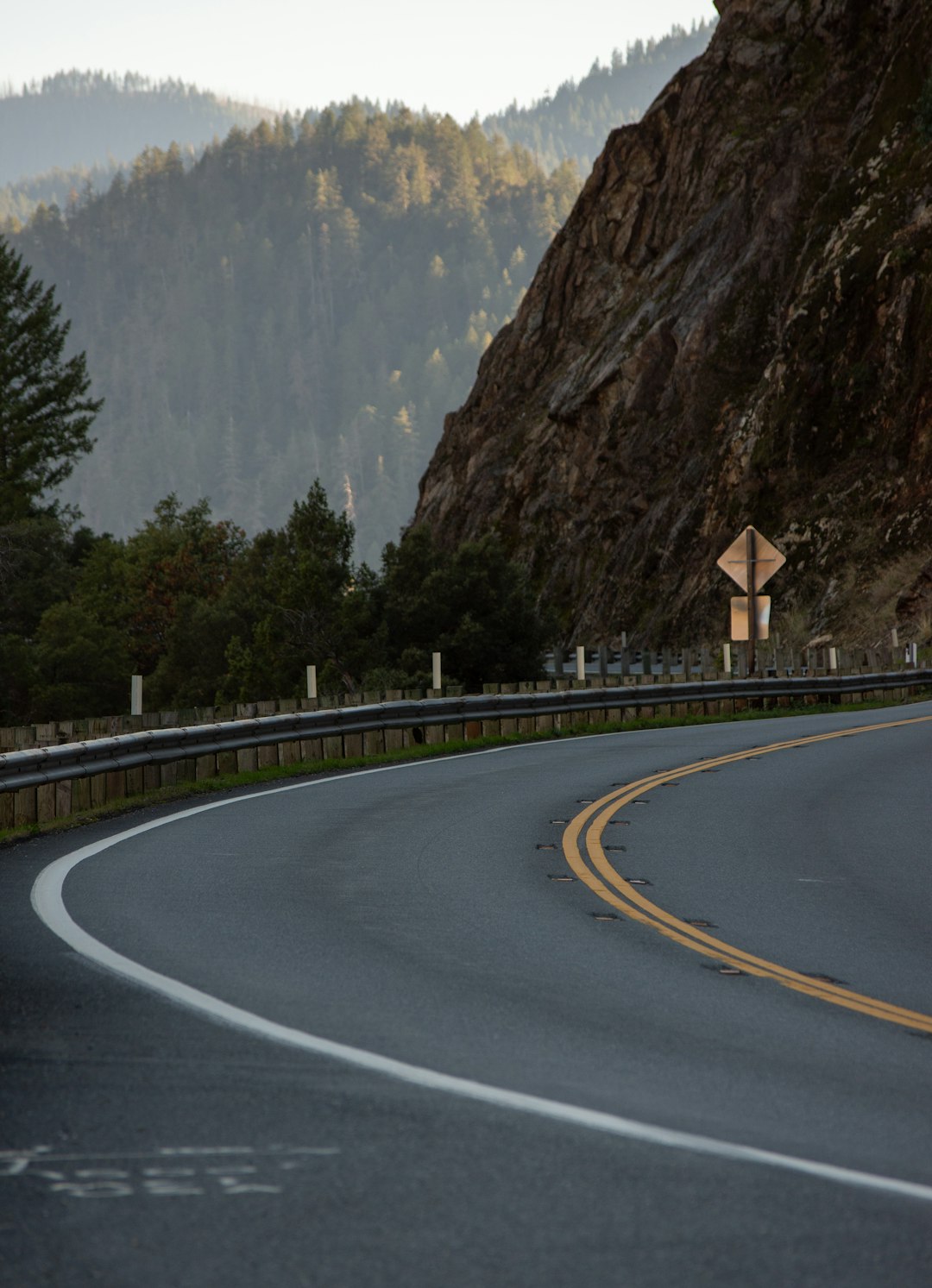 a curved road with a mountain in the background a curved road with a mountain in the background