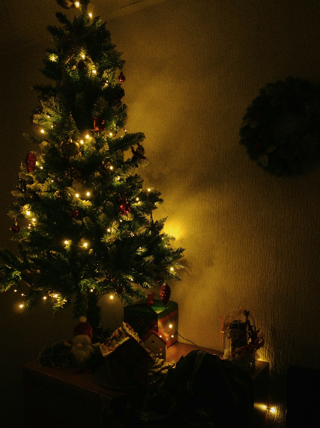 a lit christmas tree in the corner of a room